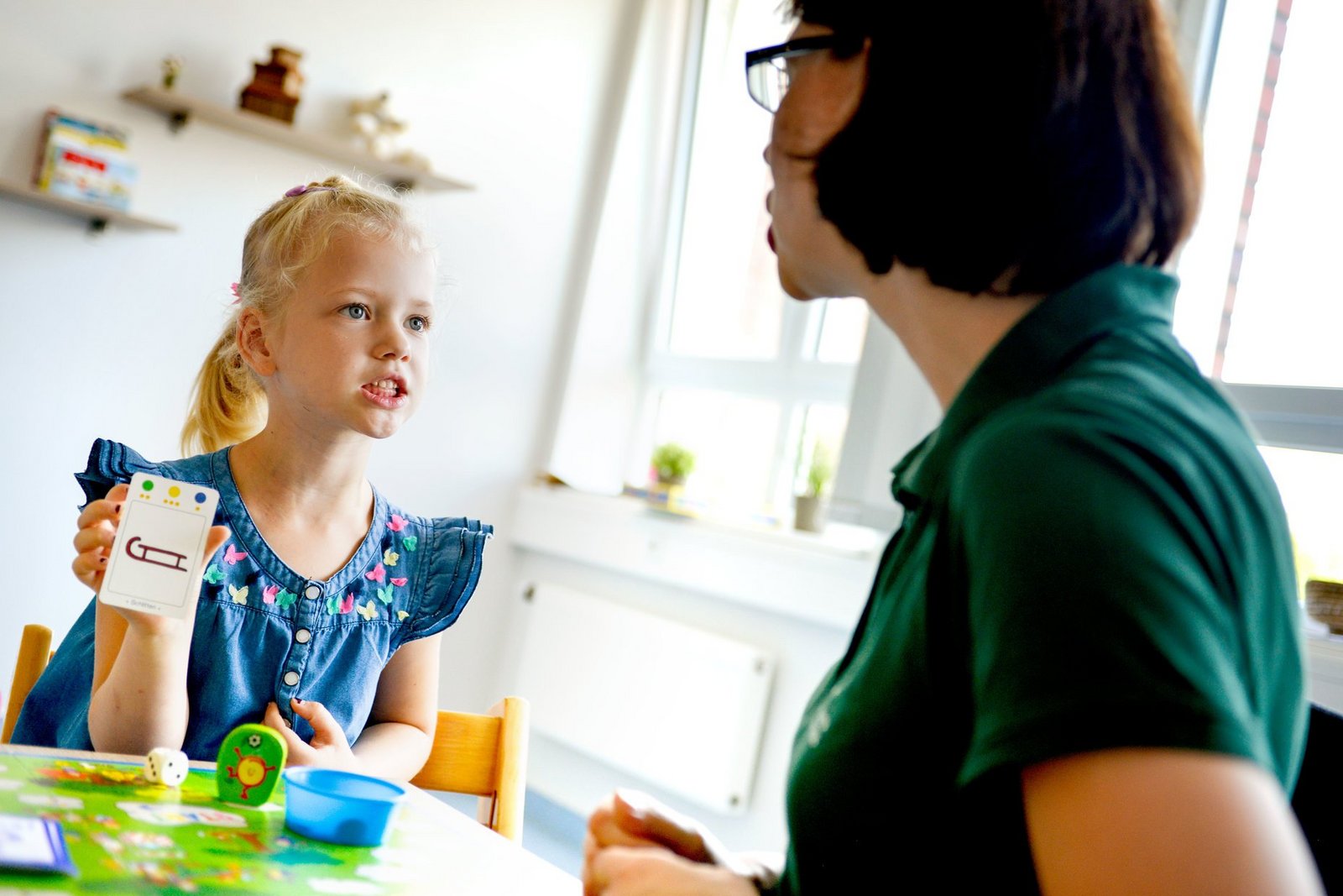 Kind und Therapeutin machen Sprechübungen